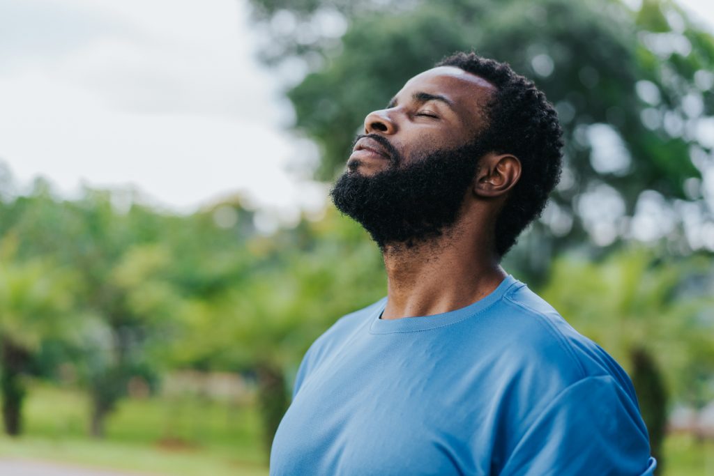 Man breathing fresh air outside relieving stress