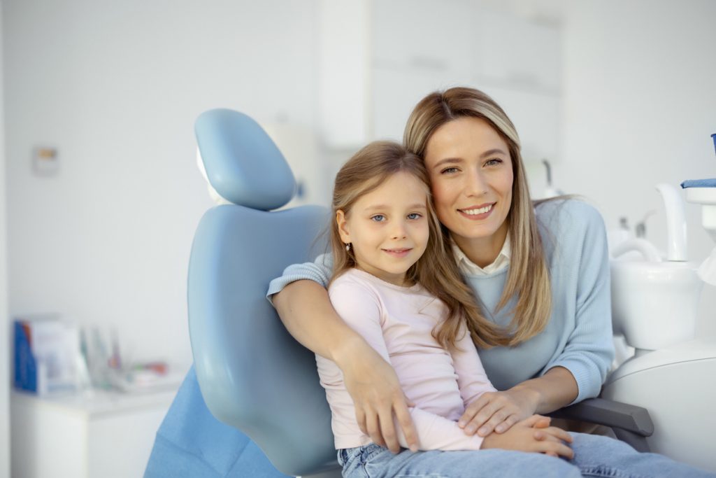 Mother and young daughter at periodontist office for frenectomy